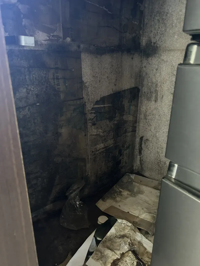 베란다 어두운 벽면에 곰팡이가 심하게 퍼져 철거 작업 중인 현장 상태 예시