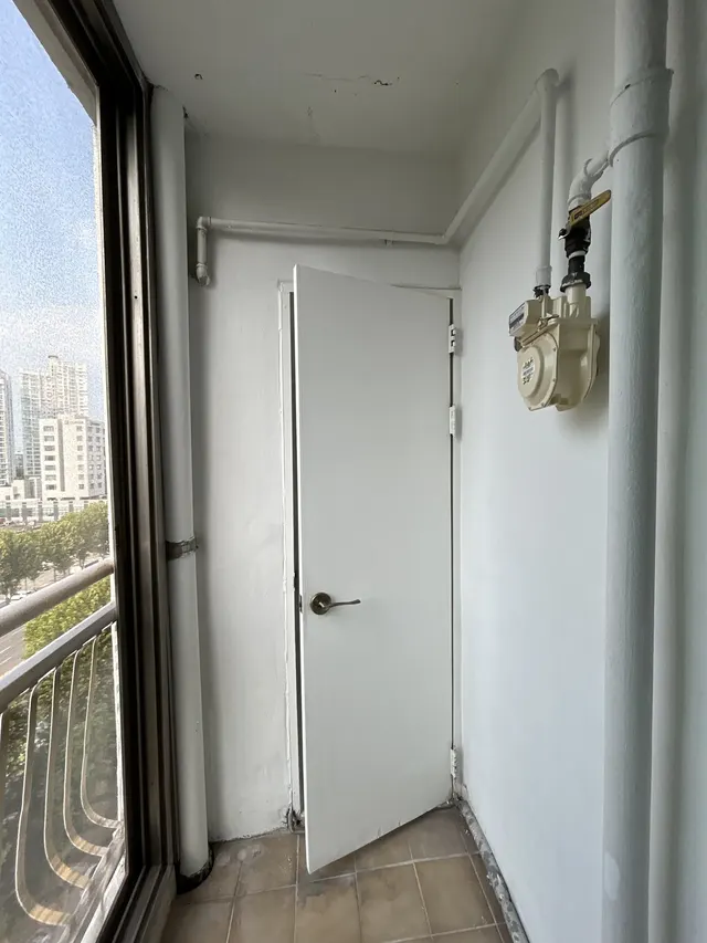 베란다 벽 흰 도장 베란다 벽과 흰 문, 가스 배관이 보이는 모습