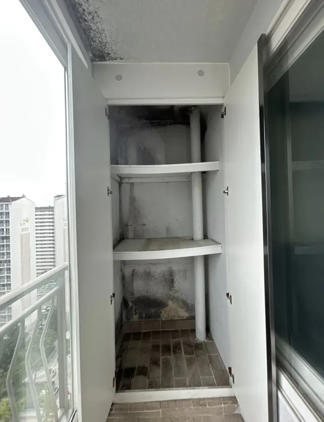 베란다 벽장 내부 곰팡이와 선반, 배관 기둥이 보이는 현장 상태 예시