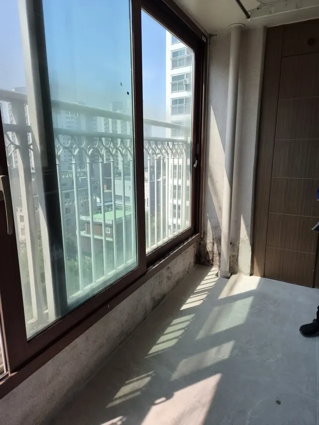 시멘트 바닥과 큰 창이 보이는 작업 전 베란다